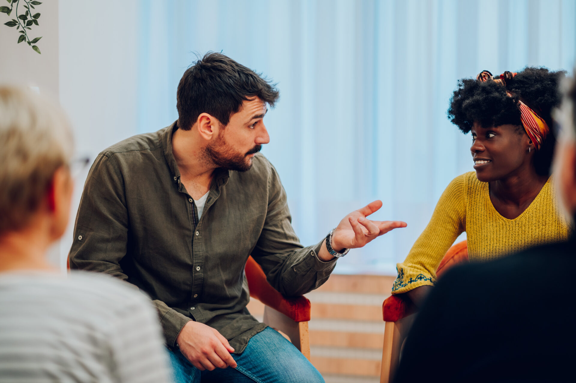 Man And Woman Talk Indoors With Group Setting 2026 03 25 03 12 41 Utc